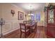 Elegant dining room with hardwood floors, wainscoting, and a classic chandelier, perfect for Gathering gatherings at 8429 Brackenfield Ave, Las Vegas, NV 89178