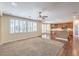 Open living room with lots of windows and a ceiling fan, leading into the kitchen at 8429 Brackenfield Ave, Las Vegas, NV 89178