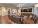 Comfortable living room with hardwood floors, plush seating, custom entertainment center, and staircase view at 8429 Brackenfield Ave, Las Vegas, NV 89178