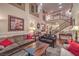 Spacious living room with soaring ceilings, iron staircase, and comfortable seating at 8429 Brackenfield Ave, Las Vegas, NV 89178