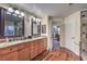 Bathroom with dual vanities, framed mirrors and wood flooring at 8429 Brackenfield Ave, Las Vegas, NV 89178