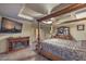 A cozy main bedroom features a fireplace, ceiling fan, tray ceiling and four-poster bed at 8429 Brackenfield Ave, Las Vegas, NV 89178