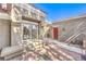 Beautifully appointed home entrance with a red front door and outdoor seating with a brick patio at 8552 Desert Holly Dr, Las Vegas, NV 89134
