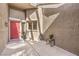 Cozy entrance featuring a red front door, outdoor seating, and a secure privacy wall at 8552 Desert Holly Dr, Las Vegas, NV 89134