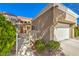 A well-maintained home exterior with a two-car garage, a red-tiled roof, and mature landscaping at 8552 Desert Holly Dr, Las Vegas, NV 89134