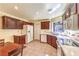Well-lit kitchen with wooden cabinetry, white appliances, and tile flooring at 8552 Desert Holly Dr, Las Vegas, NV 89134