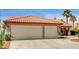 Attached two-car garage with desert landscaping and a terracotta tile roof at 8851 Quintane Ln, Las Vegas, NV 89123