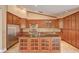 Well-lit kitchen featuring wood cabinets, stainless steel appliances, granite countertops, and an island at 8851 Quintane Ln, Las Vegas, NV 89123