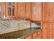 Kitchen detail featuring granite countertops, tile backsplash, and wood cabinets at 8851 Quintane Ln, Las Vegas, NV 89123