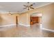 Open-concept living area with tile flooring, ceiling fans, and an archway leading to the kitchen at 8851 Quintane Ln, Las Vegas, NV 89123