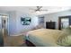 A spacious bedroom with a ceiling fan, a bed, a wall-mounted TV, and neutral colored walls at 8853 Autumn Teal Ave, Las Vegas, NV 89178