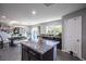 An open-concept kitchen with a large island, dark cabinets, gray walls, and wood floors at 8853 Autumn Teal Ave, Las Vegas, NV 89178