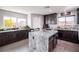 Spacious kitchen with a large granite island, dark cabinets, stainless steel appliances, and wood floors at 8853 Autumn Teal Ave, Las Vegas, NV 89178