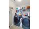 This laundry room features dark-blue front-loading washer and dryer units with white walls at 8853 Autumn Teal Ave, Las Vegas, NV 89178