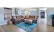 Comfortable living room featuring a stylish sectional sofa, plank flooring, and plentiful natural light at 8853 Autumn Teal Ave, Las Vegas, NV 89178