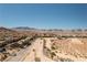 Wide street view of houses in the distance and desert landscape on either side at 8853 Autumn Teal Ave, Las Vegas, NV 89178
