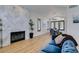 Bright living room with hardwood floors, herringbone tiled fireplace, and a view to the dining area at 8913 Saint Pierre Dr, Las Vegas, NV 89134