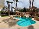 Custom pool features tropical landscaping and a rock waterfall with slide at 8913 Saint Pierre Dr, Las Vegas, NV 89134