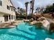 Backyard pool features rock waterfall, water slide, and lush landscaping at 8913 Saint Pierre Dr, Las Vegas, NV 89134