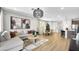 Open-concept living area featuring hardwood floors, a sectional sofa, dining table, and a modern light fixture at 91 Tardando Ave, Henderson, NV 89015