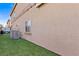 View of the backyard with artificial turf, a window, and an A/C unit at 9494 Alma Ridge Ave, Las Vegas, NV 89178