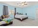 This bedroom features a ceiling fan, large windows, and comfortable furniture at 9494 Alma Ridge Ave, Las Vegas, NV 89178
