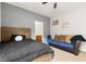 View of a bedroom with a rustic wood bed, futon, ceiling fan, and connected bath at 9494 Alma Ridge Ave, Las Vegas, NV 89178