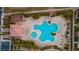 Overhead view of a community pool, surrounded by lounge chairs, greenery, and a clubhouse at 9494 Alma Ridge Ave, Las Vegas, NV 89178