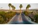 View of the main entrance to the community lined with palm trees and lush landscaping at 9494 Alma Ridge Ave, Las Vegas, NV 89178