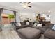 Open-concept living room showcasing a spacious layout with a large sofa and access to the patio at 9494 Alma Ridge Ave, Las Vegas, NV 89178