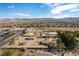 Expansive aerial view of a desert neighborhood with mountain views under a bright blue sky, showcasing the property's location at 9865 Penny Ln, Las Vegas, NV 89178