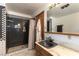 Bathroom with shower stall, wooden vanity, and checkered wall tiles at 9865 Penny Ln, Las Vegas, NV 89178