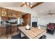 Open kitchen with wood cabinets, a black range, a breakfast bar, and a view to the living room at 9865 Penny Ln, Las Vegas, NV 89178