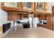 Cozy kitchen featuring wood cabinets, and light countertops with an attached breakfast bar at 9865 Penny Ln, Las Vegas, NV 89178