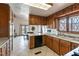 Traditional kitchen with wood cabinetry, neutral countertops, window over sink, and adjacent breakfast nook at 9865 Penny Ln, Las Vegas, NV 89178