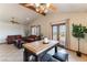 Cozy living room with tile floors, two leather sofas, a wood beam ceiling, and a view of the balcony at 9865 Penny Ln, Las Vegas, NV 89178