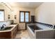 Main bathroom with double vanity, integrated soaking tub, and natural light at 9865 Penny Ln, Las Vegas, NV 89178