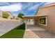 This backyard features a covered patio, artificial grass, and a stone retaining wall at 10452 Niagara Falls Ln, Las Vegas, NV 89144