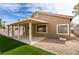 Backyard featuring a covered patio, artificial grass, and desert landscaping at 10452 Niagara Falls Ln, Las Vegas, NV 89144