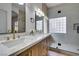 Bathroom showcasing dual sinks with a light wood vanity and a luxurious glass shower at 10452 Niagara Falls Ln, Las Vegas, NV 89144