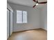 A spacious bedroom with sliding closet doors, a ceiling fan, and a large window at 10452 Niagara Falls Ln, Las Vegas, NV 89144