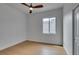 A bright bedroom with wood flooring, ceiling fan, and a view of an exterior wall of glass blocks at 10452 Niagara Falls Ln, Las Vegas, NV 89144