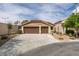 Home exterior featuring a three car garage, desert landscaping, and a tile roof at 10452 Niagara Falls Ln, Las Vegas, NV 89144