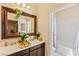 Bathroom with double sinks, decorative mirror, and a separate bathtub behind a curtain at 12245 Olivetta Ct, Las Vegas, NV 89138