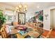 Formal dining room featuring a glass-top table set for six, wood flooring, and statement lighting at 12245 Olivetta Ct, Las Vegas, NV 89138