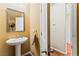 Charming half-bathroom with a pedestal sink, decorative mirror, and neutral color scheme at 12245 Olivetta Ct, Las Vegas, NV 89138