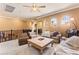 Comfortable living area featuring plush seating, a ceiling fan, and bright natural light at 12245 Olivetta Ct, Las Vegas, NV 89138