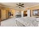 A spacious main bedroom with a decorative ceiling fan, cozy seating area, and access to the ensuite bathroom at 12245 Olivetta Ct, Las Vegas, NV 89138