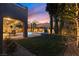 Backyard with lush lawn, pool, covered patio, and elegant landscaping, perfect for enjoying summer evenings at 193 Elder View Dr, Las Vegas, NV 89138