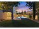 Backyard with lush lawn, pool, covered patio, and elegant landscaping, perfect for enjoying summer evenings at 193 Elder View Dr, Las Vegas, NV 89138